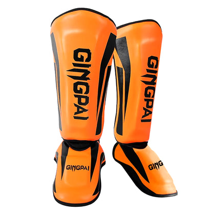 kickboxing shin guard pads in vibrant orange color, designed for martial arts and combat sports protection.