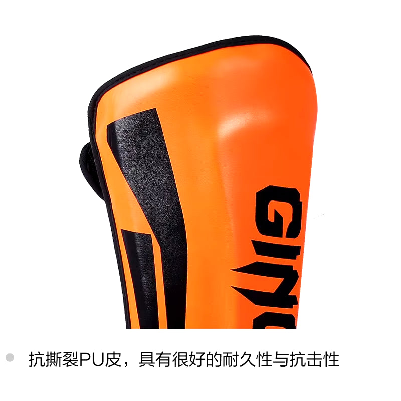 kickboxing shin guard pads in orange, made of durable PU leather for martial arts protection.